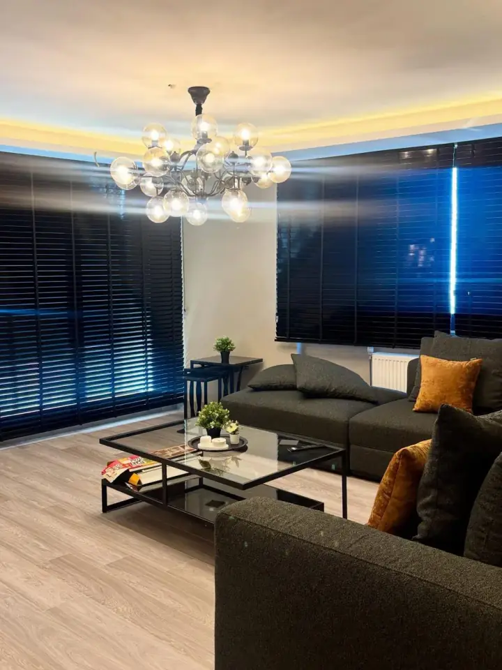 Koyu ahşap jaluzi ve avize ile zarif salon
