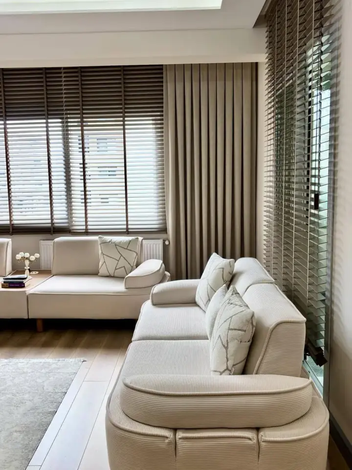 Modern salonda ahşap jaluzi ve dalga drape perde, krem kanepe